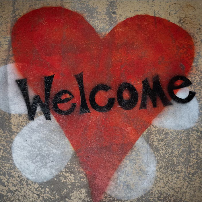 red heart with black letters spelling out the word Welcome superimposed.